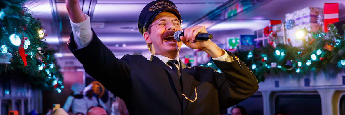 Actor portraying Tom Hank's Train Conductor for The Polar Express singing into a microphone