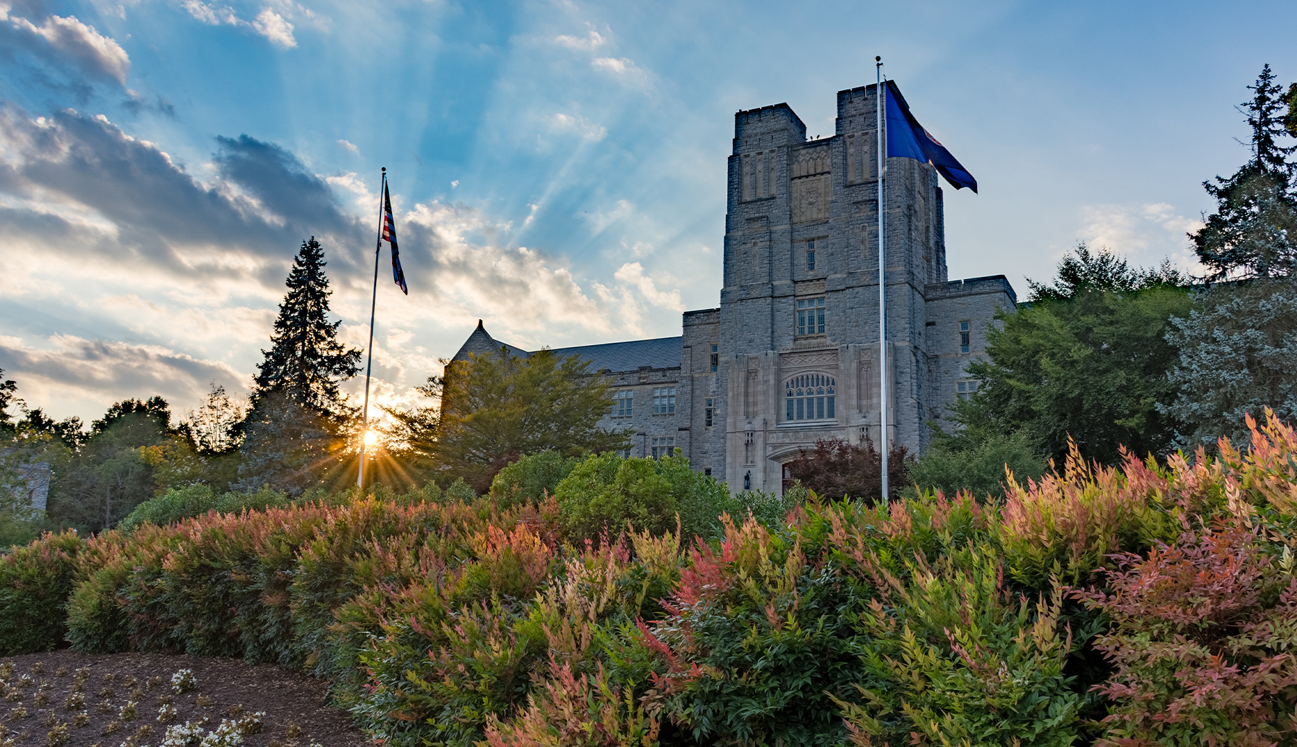 View of an old stone building with the sun setting in the background at at Virginia Tech