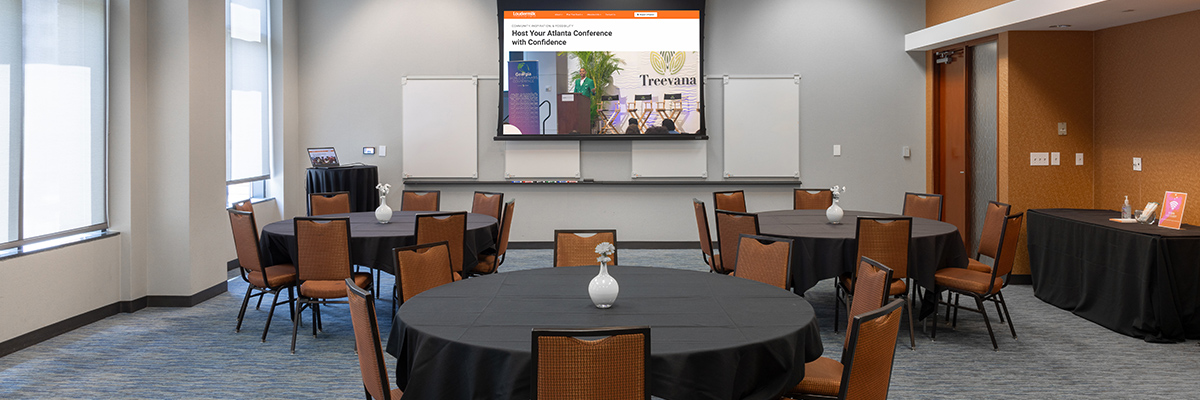 A conference room in the Loudermilk Conference Center in Atlanta, GA with tables and a projection