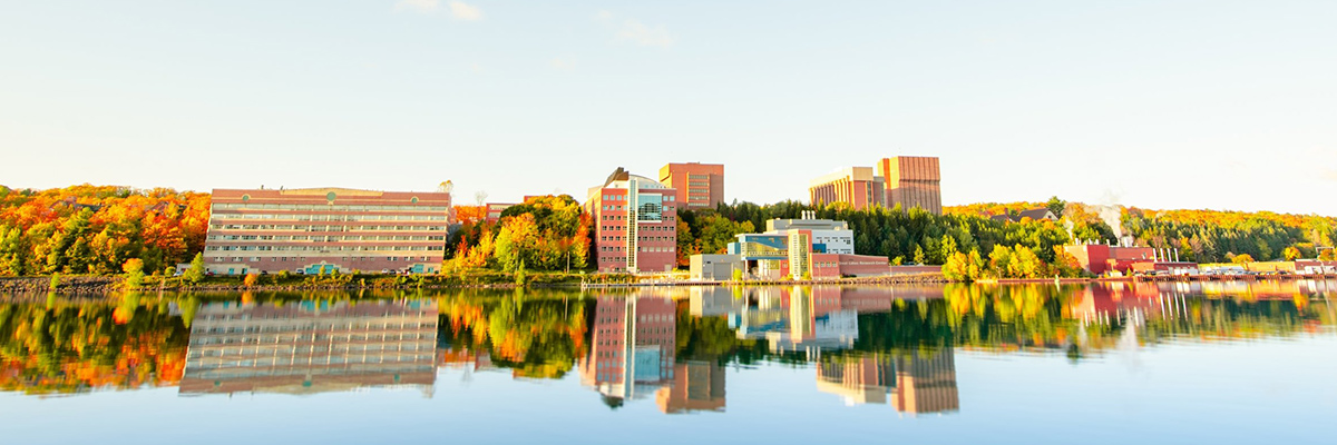 View of Michigan Technological University shot over a lake with the buildings reflecting of the still water